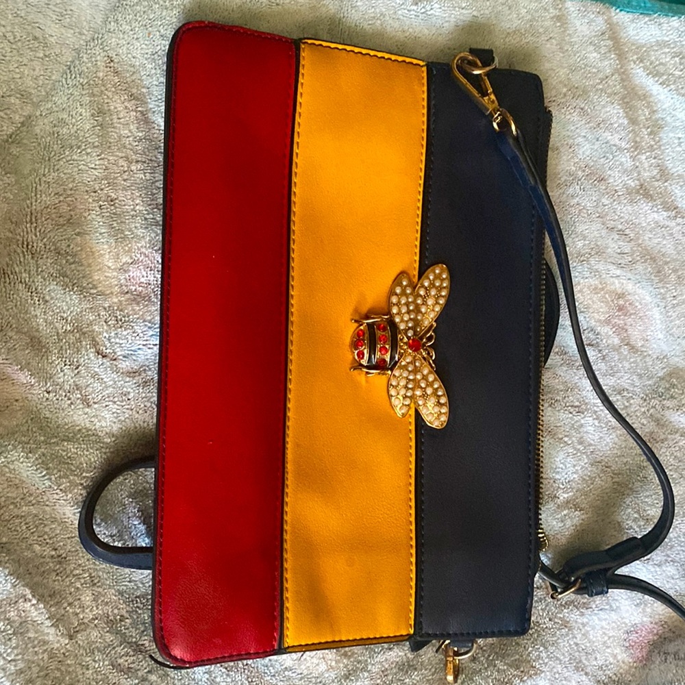 A gently used handbag that has a beautiful bed on the front